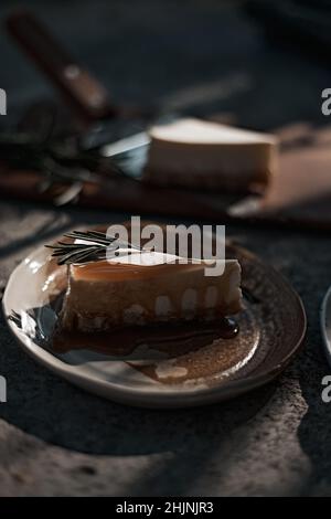 Scheibe Käsekuchen mit Karamellsauce auf dem Teller. Stockfoto