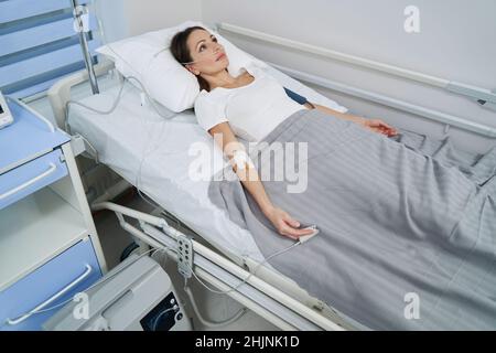 Patient während der intravenösen Therapie an Sauerstoffkonzentrator angeschlossen Stockfoto