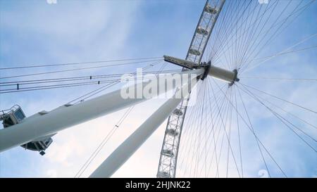 Ansicht des modernen Riesenrads auf blauem Himmel Hintergrund. Aktion. Das Riesenrad funktioniert an klaren Tagen nicht. Viele Leitungen in Riesenrad verbunden. Stockfoto