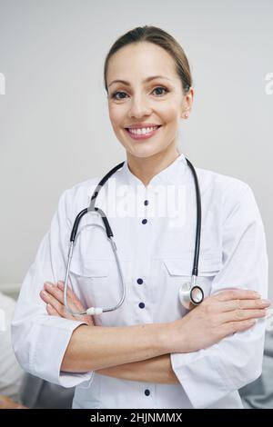 Fröhliche Ärztin, die auf der Krankenstation steht Stockfoto
