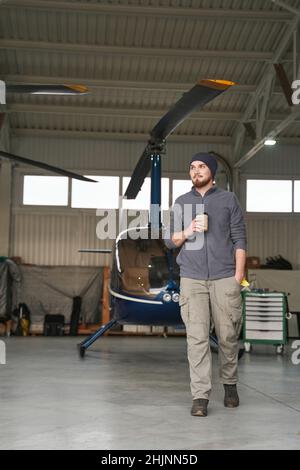 Bärtiger Mann, der mit einem Kopter in der Garage läuft Stockfoto