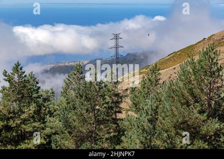 MADEIRA, PORTUGAL - 23. AUGUST 2021: Es handelt sich um eine Stromliniensäule, die auf den Hängen der Insel auf Höhe der Wolken steht. Stockfoto