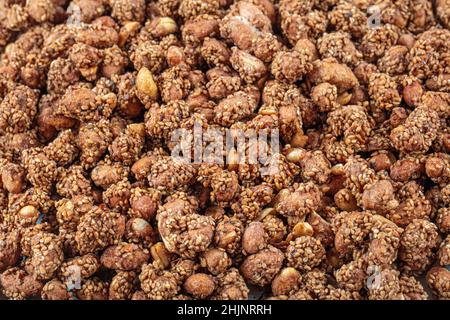 Honig mit Sesamnüssen (Erdnüsse mit Sesam). Nahaufnahme der braunen Erdnüsse und Erdnusssammlung. Konzept Erdnüsse und Sesam, Sesam s Stockfoto