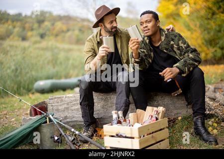 Männer mit Alkohol beim Angeln im Freien Stockfoto