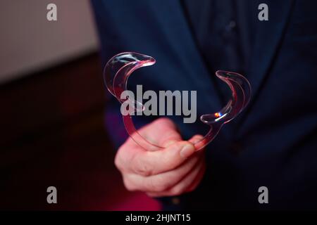 Krankenschwester, die einen Zahnaufroller in den Händen hält. Nahaufnahme der Wangenaufrollvorrichtung in den Händen. Lip Retractors Stockfoto