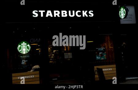 Das Starbucks-Café-Schild leuchtet in der Nacht High Street Lincoln City 2022 auf Stockfoto