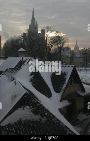 Winteransicht auf stalinistische Hochhäuser im Moskauer Zoo. Gelber Sonnenuntergang, graue Wolken. Stockfoto