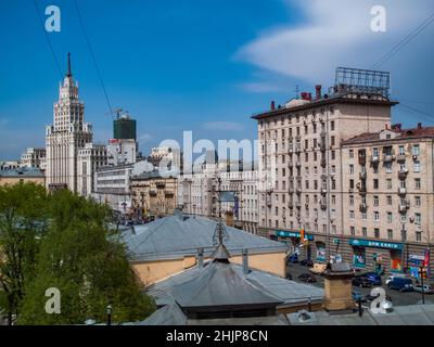 Moskau, Russland. Eines der stalinistischen Hochhaus-Gebäude links. „Wolkenkratzer“ am Garden Ring. Sowjetisches Wohnhaus rechts und Dach im Vordergrund. Stockfoto