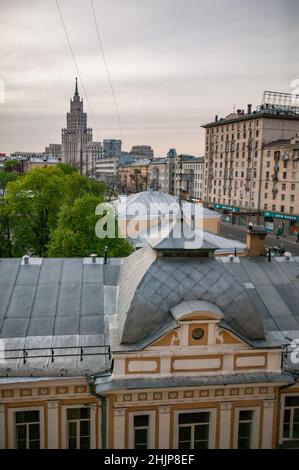 Moskau, Russland. Eines der stalinistischen Hochhaus-Gebäude links. „Wolkenkratzer“ auf dem Gartenring. Sowjetisches Wohnhaus rechts und Dach im Vordergrund. Stockfoto