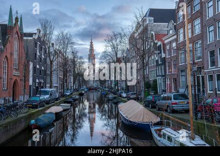 Hillsong Kirche bei Sonnenuntergang mit mehreren geparkten Fahrrädern und Booten auf einem Amsterdamer Kanal Holland Stockfoto