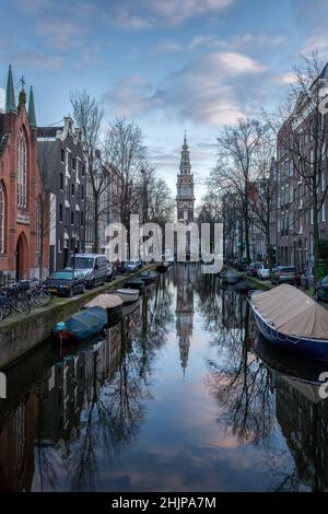 Hillsong Kirche bei Sonnenuntergang mit mehreren geparkten Fahrrädern und Booten auf einem Amsterdamer Kanal Holland Stockfoto