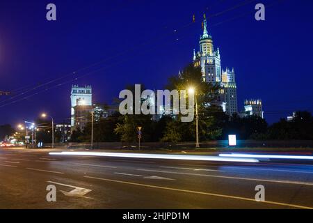 Das Hochhaus am Kotelnicheskaya-Ufer des Moskwa-Flusses nannte sich Stalin-Wolkenkratzer mit den Stadtlichtern am tiefblauen Himmel am Abend Stockfoto