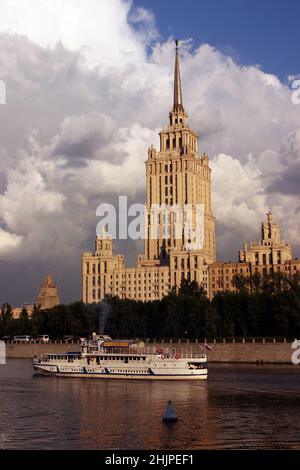 Stalinistischer Wolkenkratzer Hotel Ukraine (Radisson) ein Sonnenuntergang am blauen Himmel mit Wolken bei Abendlicht. Sowjetische Architektur in Moskau, Russland. Touristenboot Stockfoto