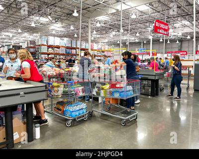 Orlando, FL USA - 6. Juni 2021: Der Check-out-Schalter im Costco-Lebensmittelgeschäft mit Mitarbeitern, die verschiedene Kunden auschecken. Stockfoto