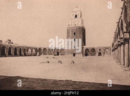 Majestätisch in seiner Massivität erhebt sich der Minarel von Kairwans großer Moschee aus einem 38.000 Quadratmeter großen, mit einer Klausur bedeckten Hof. Tunesien (1923) Stockfoto