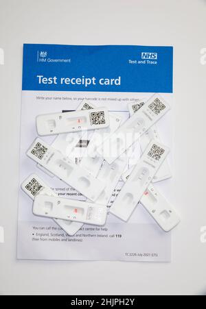 Gebrauchte Ergebnisse des lateralen NHS-Durchfluss-Tests, die positive und negative Ergebnisse auf der Quittungskarte des NHS-Tests zeigen, weiß. Stockfoto