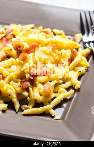 Spätzle mit gebratenem Speck und Zwiebeln Stockfoto