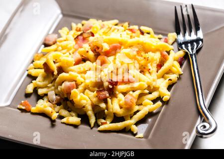 Spätzle mit gebratenem Speck und Zwiebeln Stockfoto