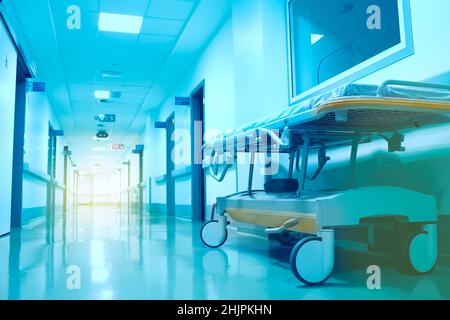 Modernes Rollbett im Krankenhausflur, dessen Ende von einem hellen Blitz beleuchtet wird. Stockfoto