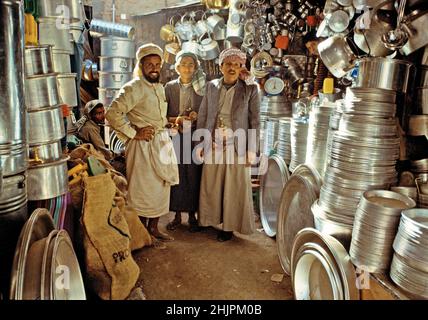 Jemenitische Männer mit einem Jambiya an der Taille in einem Kochtopf-Laden auf dem Sana'a-Markt. Sanaa Hauptstadt des Jemen. Stockfoto