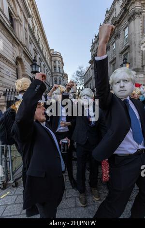 Flash-Mob von „partygate“-Anti-Boris Johnson-Demonstranten, die blonde Perücken und Gesichtsmasken von Boris Johnson tragen, vor den Toren der Downing Street, Großbritannien Stockfoto