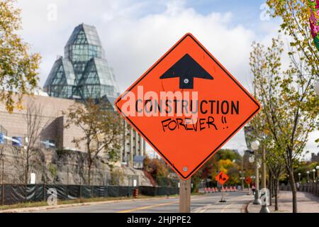 Ottawa, Kanada - 14. Oktober 2021: Warnbau vor orangefarbenem Straßenschild in der Straße der Innenstadt Stockfoto