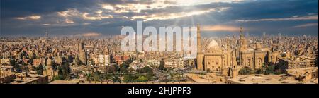 Panoramablick auf Kairo und Sonnenstrahlen über die Sultan Hassan Moschee Stockfoto
