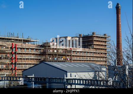 Slough, berkshire, Großbritannien. 31st. Januar 2022. Das ehemalige Werk der Horlicks-Fabrik in Slough wird derzeit von Berkeley einem großen Bauprojekt unterzogen. Neue und renovierte Apartments werden gebaut. Ein Teil der alten Fabrik wird in Wohnungen umgestaltet und das ikonische Wahrzeichen des Horlicks-Uhrturms und des Schornsteins bleibt erhalten. Slough befindet sich auf der Crossrail-Linie, die heute als Elizabeth Line bekannt ist und voraussichtlich in der ersten Hälfte des Jahres 2022 in Betrieb gehen wird. Immobilienspekulanten kaufen viele Immobilien in Slough auf. Quelle: Maureen McLean/Alamy Stockfoto