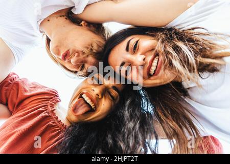 Beste Freunde machen ein Selfie von unten mit Smartphone im Urlaub - Gruppe von glücklichen multirassischen Touristen, die ein lustiges Foto machen - Freundschaft und Spaß Konz Stockfoto