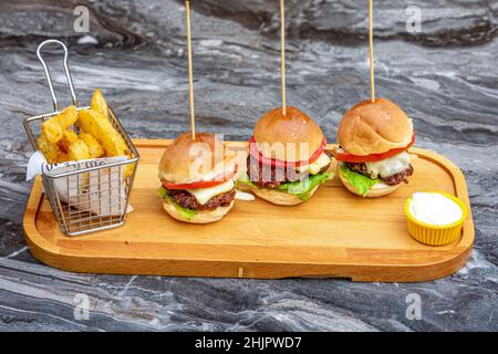 Drei Mini-Burger mit Huhn und Fleisch serviert mit französisch Pommes Stockfoto