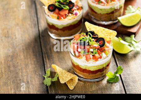 Sieben Schichten Dip in einzelne Tassen, mexikanische Vorspeise Stockfoto