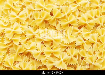 Haufen von rohen Farfalle italienischen Pasta Hintergrund. Zutat für die mediterrane Küche Stockfoto