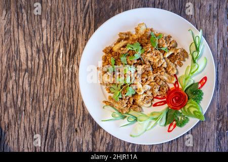 Gebratener Tintenfisch mit Knoblauch, knuspriger Teig, asiatisches Street Food auf einem Holzboden. Stockfoto