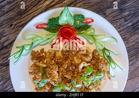 Gebratener Tintenfisch mit Knoblauch, knuspriger Teig, asiatisches Street Food auf einem Holzboden. Stockfoto