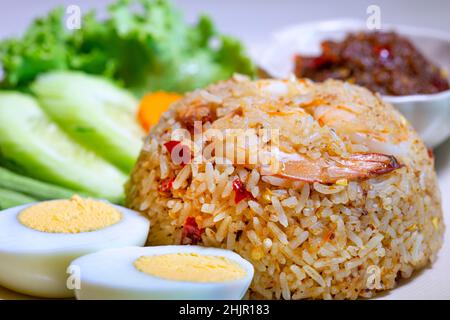 Gebratener Reis mit Tamarindenpaste und Garnelen, das Gericht mit gekochten Eiern und frischem Gemüse anbraten. Stockfoto