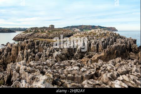 Felsformationen der Insel San Pedro und Islita de la Oliva am Strand von Noja in Kantabrien, Nordspanien Stockfoto