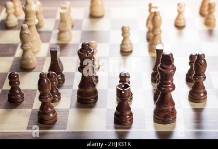 Schachbrett mit Schachspiel wird gespielt. Von oben nach unten. Schwarze Stücke im Vordergrund Stockfoto