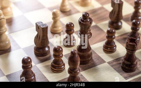 Schachbrett mit Schachspiel wird gespielt. Von oben nach unten. Schwarze Königin und Ritter im Fokus Stockfoto