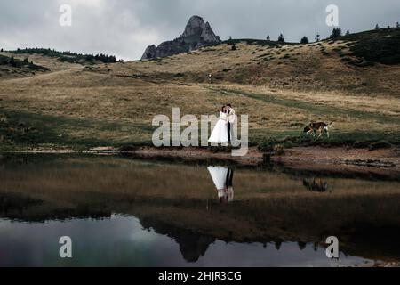 Paar umarmen, während in der Nähe des Sees in der Natur stehen Stockfoto