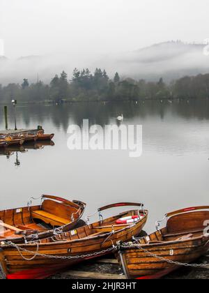 Ruhige, frühmorgendliche Aussicht über den See Windermere im Lake District von Großbritannien, mit den Bergen im Hintergrund, die in MIS gehüllt sind Stockfoto