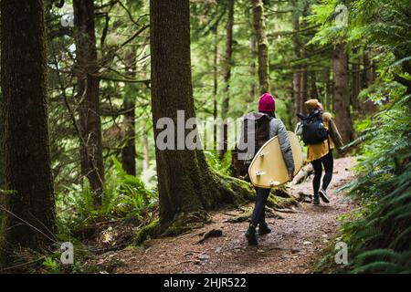 Female Surfer wandern mit einer Freundin zum Strand von Oregon Stockfoto