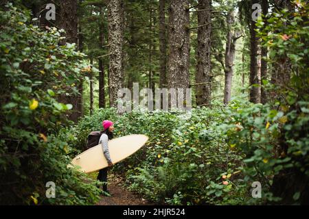 Female Surfer Walking Naturlehrpfad zum Oregon Strand Stockfoto