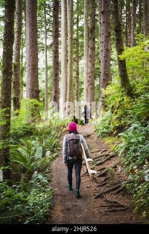 Female Surfer Walking Naturlehrpfad zum Oregon Strand Stockfoto