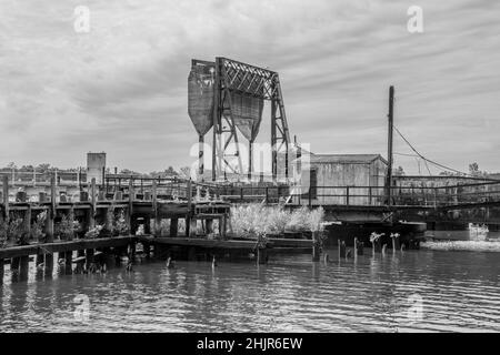 Eine alte Bascule-Eisenbahnbrücke (auch als Zugbrücke oder Hebebrücke bezeichnet) an einem grauen Tag mit einem Gegengewicht. In schwarz und weiß.