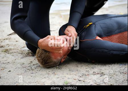 Lektion der künstlichen Atmung. Rettungsschwimmer, der Mund-zu-Mund-Beatmung ertrinkt. Stockfoto