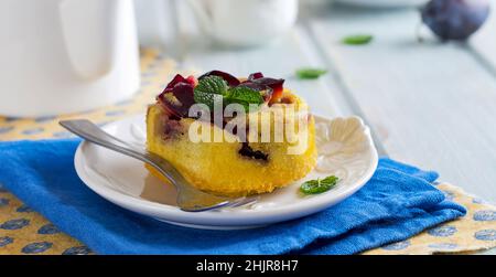 Hausgemachte Pflaumenklafoutis oder Pudding auf weißem Keramikplatte. Rustikale hausgemachte Pflaume Backwaren Selektive Konzentration. Stockfoto