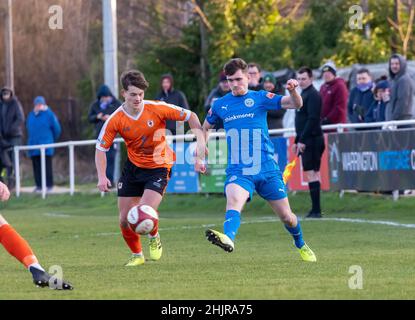 Der Warrington Rylands 1906 FC war Gastgeber des Glossop North End für ein nicht-League-Spiel der Saison 2021-2022. James Neild überquert den Ball Stockfoto