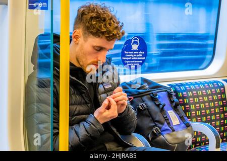 London, Großbritannien. 31st Januar 2022. Die U-Bahn in der ersten Woche nach den Regeln zum Maskentragen in der Öffentlichkeit werden nach Omicron gelockert. Masken sind im öffentlichen Verkehr weiterhin obligatorisch, aber da sie jetzt keine gesetzliche Anforderung mehr sind, ignorieren immer mehr Menschen die Regeln trotz Beschilderung. Die Verwirrung unter den Masken setzt sich im Untergrund fort, vor dem Hintergrund der Regelflexibilität in Downing Street. Kredit: Guy Bell/Alamy Live Nachrichten Stockfoto