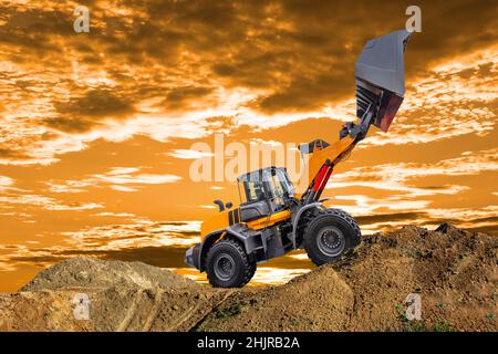 Bagger arbeiten auf der Baustelle vor dem dramatischen Himmel Stockfoto