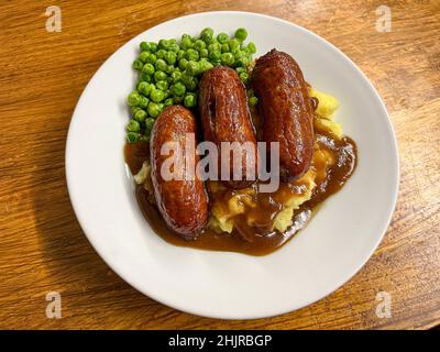 Abendessen mit Wurst und Maische mit Erbsen und Soße Stockfoto